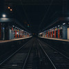 A train station taken from the side, in the middle of the rails
