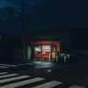 Two Coca Cola dispenser lighted in the middle of the street in the dark
