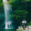 Tourists taking pictures of themselves in front of a beautiful waterfall 