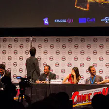 Pour la petite histoire, Christian Bujeau (The lord) racontait une histoire un peu longue et sans raport direct visible avec le sujet. 
Ou quand hero corp est passé par l'histoire de Rouletabille.
Simon Astier, est du coup en train de vagabonder sur la scène en atendant la fin. Surement pour masqué son rire nerveux.
La photo à été prise lorsque l'histoire (sans fin) se terminait.
https://www.flickr.com/photos/ztec/9212117184/