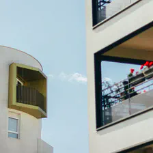 two building with two balcony. One with flower and another with a golden border. The flower one is blurry. There is grain on the picture, suggesting it is old, or is it ? 
https://www.flickr.com/photos/ztec/53149082084/
