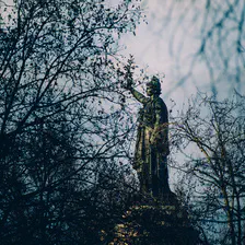 The République statue behind trees.