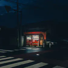 Two Coca Cola dispenser lighted in the middle of the street in the dark