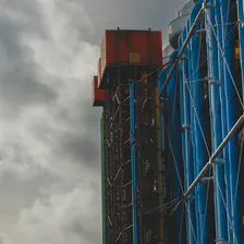 Side of Beaubourg building with two red box on top of industrial building. They look like elevators, but are not.