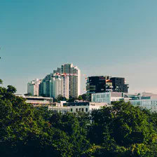 Tall building seen from afar with trees around.
