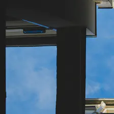 Blue sky with building shapes visible taken from below.