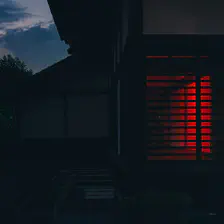 A house taken in the dark. A red glow come from the inside