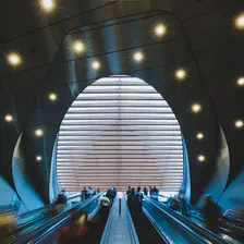 Multiple mechanical stairs going up to an erg shape ceiling 