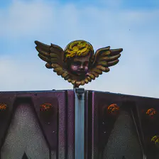 A little ange on top of an attraction ride.