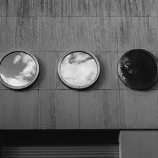 3 round windows on a concrete wall