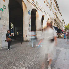 A person waiting surrounded by faded people. 