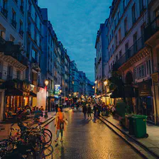 street of Paris at early night with streets and shops light bouncing of the pavement. Some People are walking on the streets, some are in bars and restaurants. 
https://www.flickr.com/photos/ztec/53213546684/