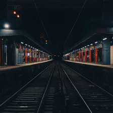 A train station taken from the side, in the middle of the rails