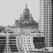 Sacré-coeur in the back (in the center of the frame), and tall modern building surrounding it in the "front" 